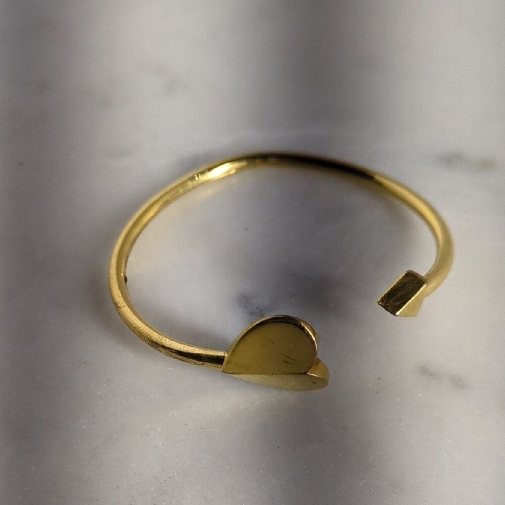 Kate Spade New York Heritage Spade Flex Cuff bracelet in a gold-tone finish.